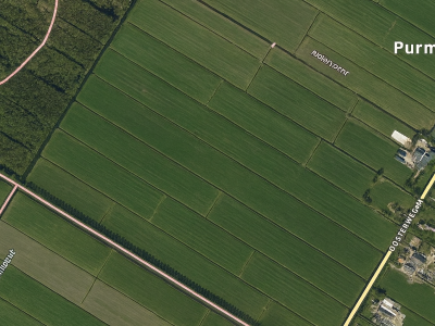 Scherpe satellietfoto van het Purmergebied met landbouwpercelen, watergangen Molentocht en Middentocht, en de Oosterweg in Noord-Holland.